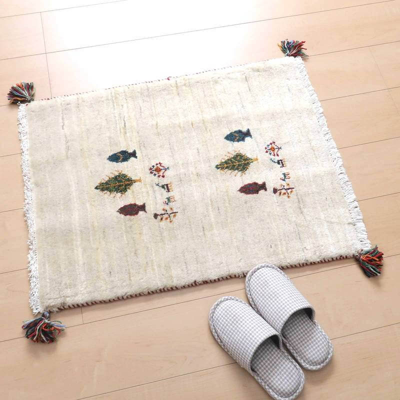 白を基調にした手織りウールのギャッベラグが、温かみのあるペルシャ絨毯専門店の床に敷かれている。