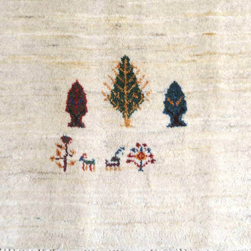 手織りのペルシャ絨毯専門店から通販で購入できる、ウール素材のギャッベラグには、自然をモチーフにした木と動物の柄が丁寧に織り込まれている。