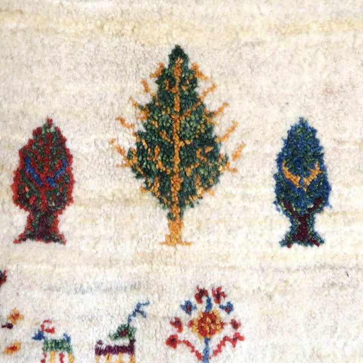 手織りのギャッベラグに描かれた色鮮やかな木々の模様が、ウール素材の柔らかな風合いの中に浮かび上がっている。