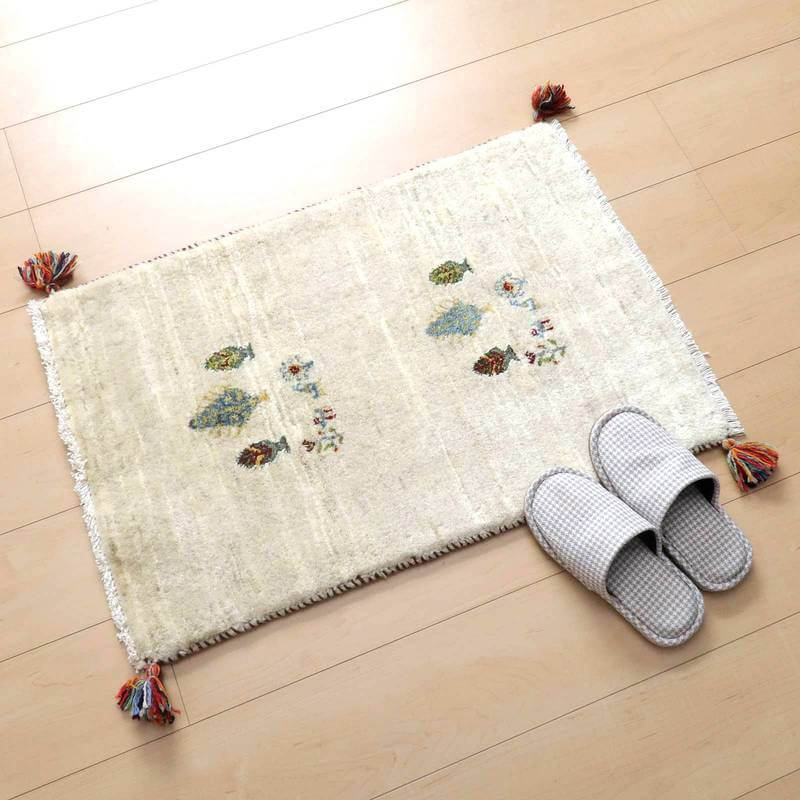 ナチュラルなウール素材で手織りされたギャッベラグが、ペルシャ絨毯の専門店から通販で届けられ、優しい色合いと繊細な柄が床に落ち着きを添えている。