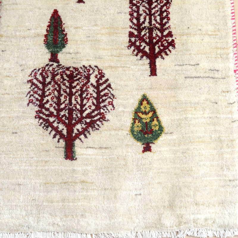 手織りのギャッベラグは、温かみのあるウール素材にペルシャ絨毯らしい木の模様が丁寧に織り込まれ、専門店の通販でも魅力が際立っている。