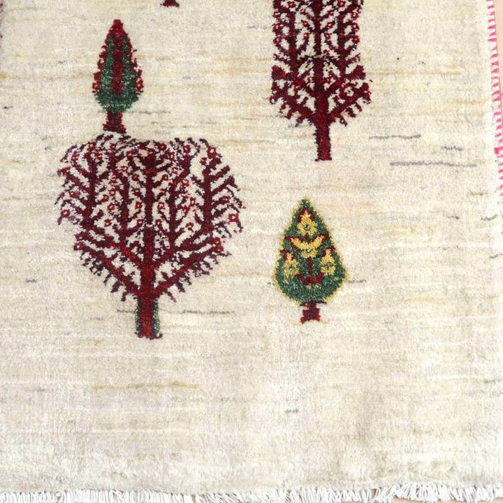 手織りのギャッベラグは、温かみのあるウール素材にペルシャ絨毯らしい木の模様が丁寧に織り込まれ、専門店の通販でも魅力が際立っている。