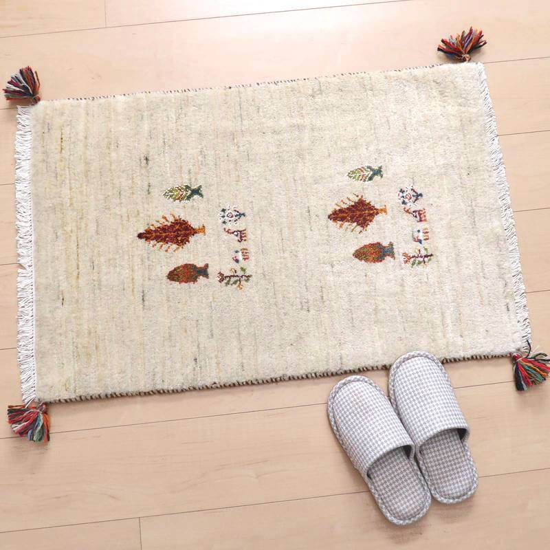 手織りのギャッベラグが床に敷かれ、色とりどりのタッセルとウールの温かさが玄関に落ち着きを与えている。