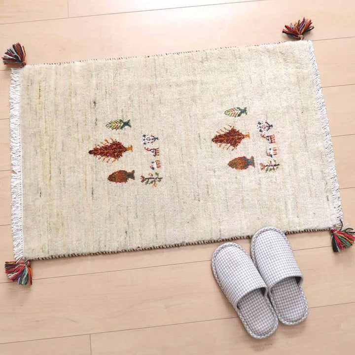 手織りのギャッベラグが床に敷かれ、色とりどりのタッセルとウールの温かさが玄関に落ち着きを与えている。