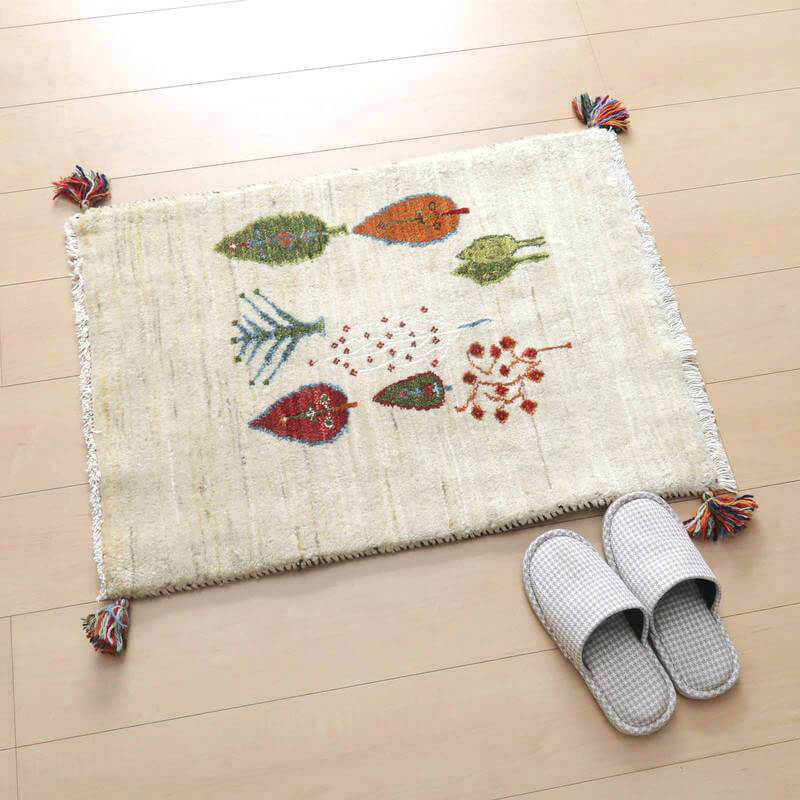 ウール素材の手織りギャッベラグがナチュラルな色合いで床に敷かれ、ペルシャ絨毯のような伝統的な模様が温かみを感じさせる一枚です。