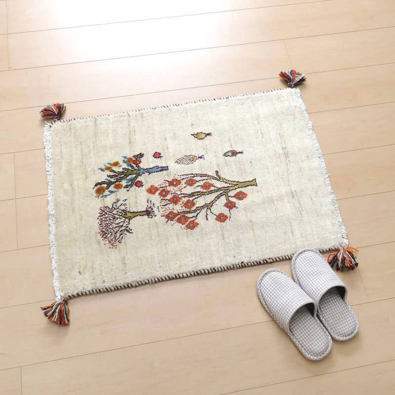 色彩豊かな模様が施された手織りのギャッベラグが、ペルシャ絨毯専門店より通販可能で、ウールの温かみが床に広がっている。