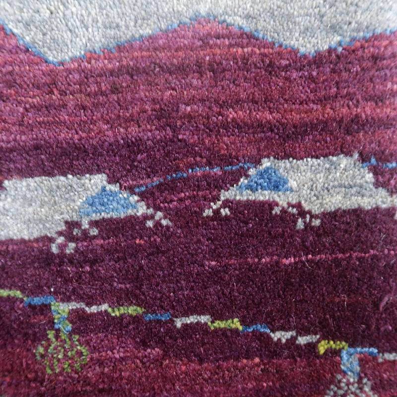 深い紫色の手織りウールギャッベラグの織り目が際立ち、ペルシャ絨毯専門店の通販で購入可能です。