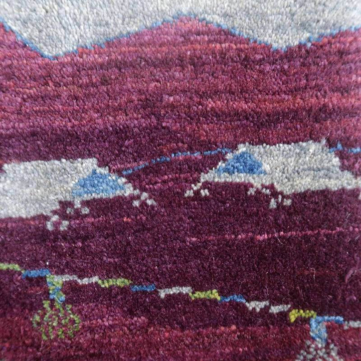 深い紫色の手織りウールギャッベラグの織り目が際立ち、ペルシャ絨毯専門店の通販で購入可能です。