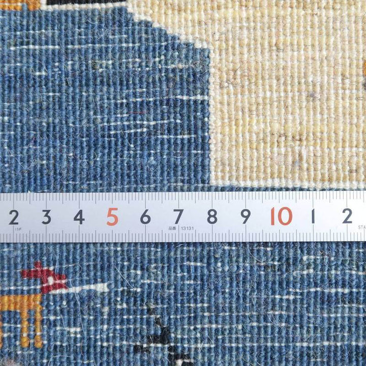 青とベージュの色合いが美しい手織りウールのギャッベラグが、定規でその織りの密度を詳細に示しています。