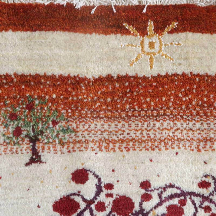 太陽と木が丁寧に織り込まれた赤と白の手織りギャッベラグは、ぬくもりを感じさせるデザインが際立っている。