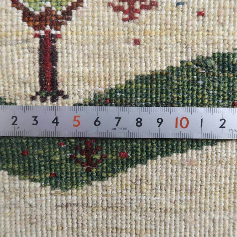 手織りのペルシャ絨毯専門店から通販可能なウール製ギャッベの織り目が、定規でその細やかさを測られている。