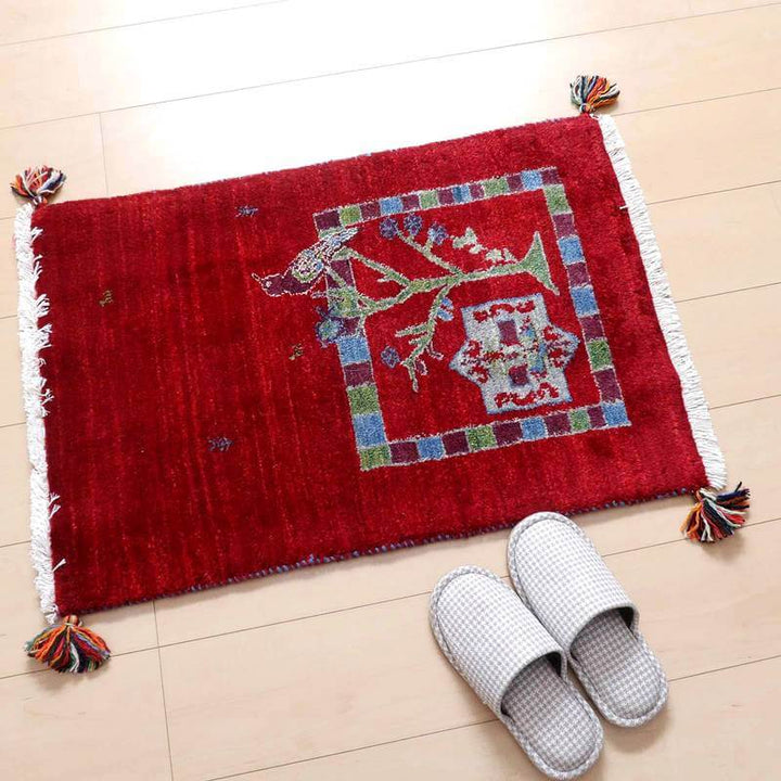 赤い手織りのウール製ギャッベラグが床に置かれ、ペルシャ絨毯専門店の通販で購入できる一品が華やかに見える。