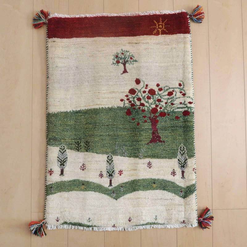 ギャッベ／ルリバフ 90×63cm（HSS-71767）は、緑と赤の木々が描かれた手織りウールのギャッベラグが、ペルシャ絨毯専門店の通販で提供される温かみあるデザインが床に広がっている。
