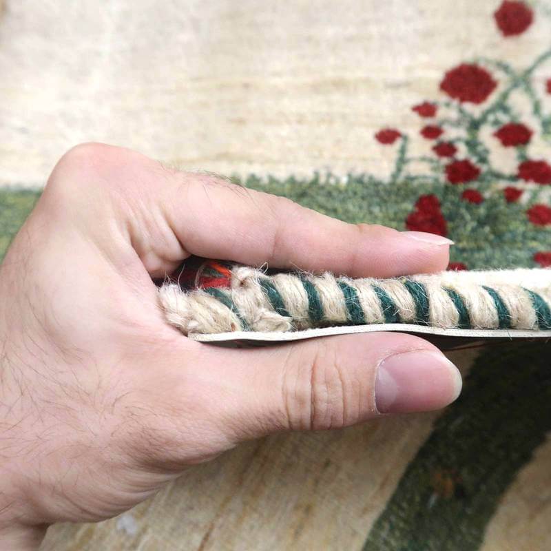 手織りウールで丁寧に作られたギャッベラグの厚みが、手元で確認できる接写画像に、ペルシャ絨毯専門店の通販商品が見える。