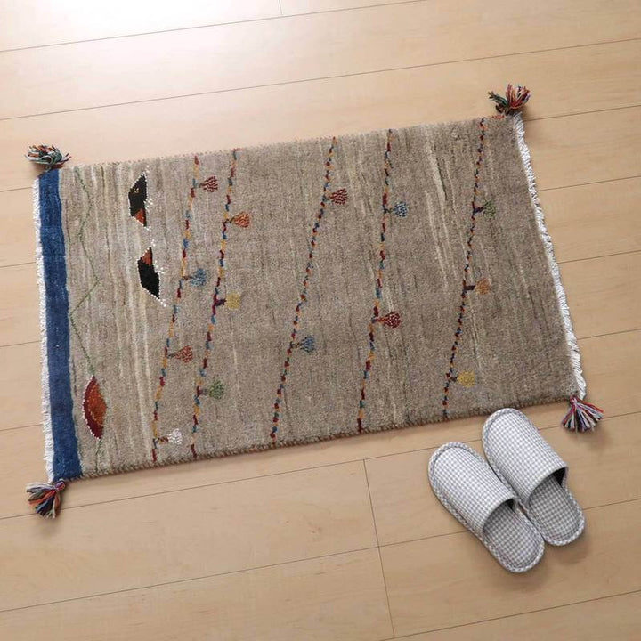 手織りのギャッベラグがナチュラルなウール素材で玄関に敷かれ、カラフルな模様がペルシャ絨毯の魅力を引き立てている。