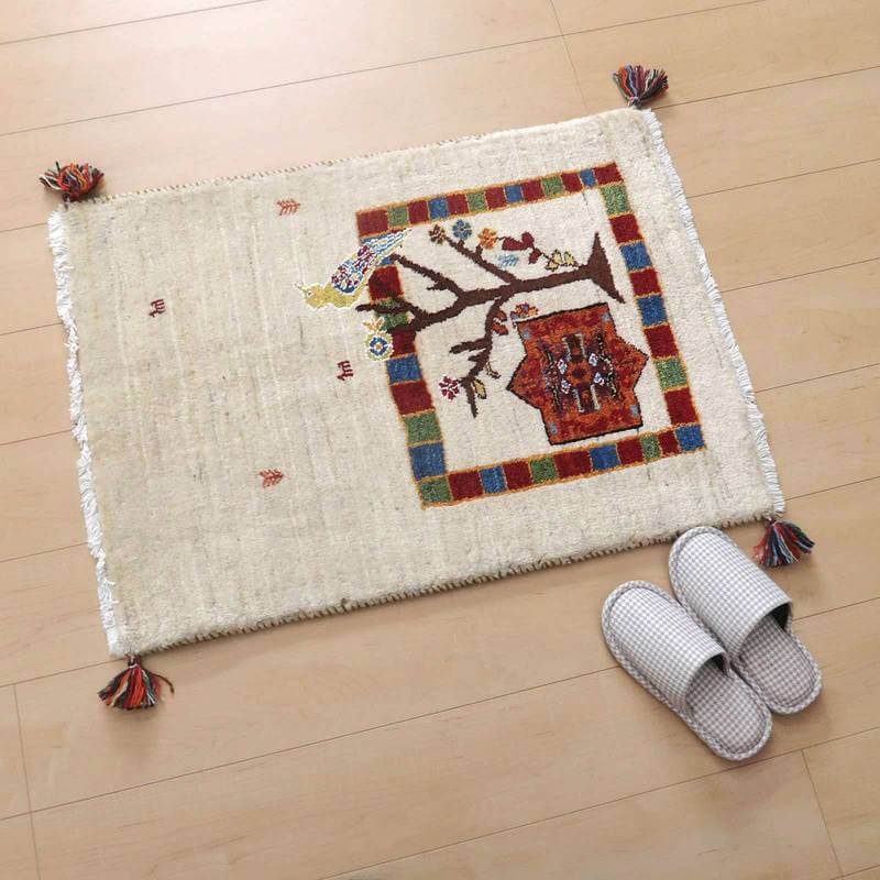 手織りのウールギャッベラグが床に広がり、ペルシャ絨毯専門店の通販商品として、色鮮やかな模様が際立つ。