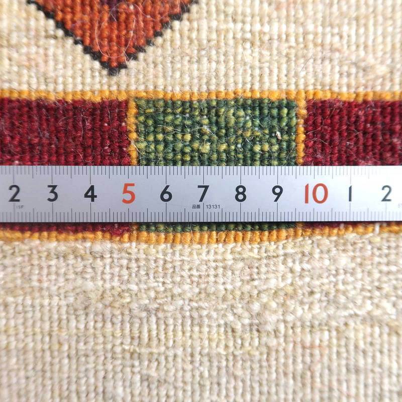 手織りのギャッベラグの織り目が、定規で測られて細やかなウールの質感と色彩が際立っている。