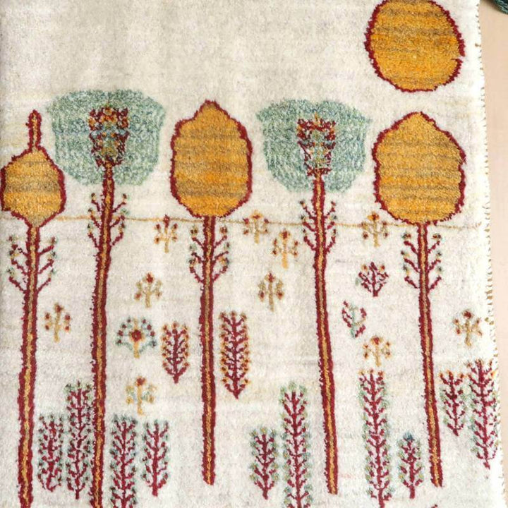 手織りのウールで作られたギャッベラグは、ペルシャ絨毯の専門店で通販可能な繊細な木々の模様が優雅に描かれている。