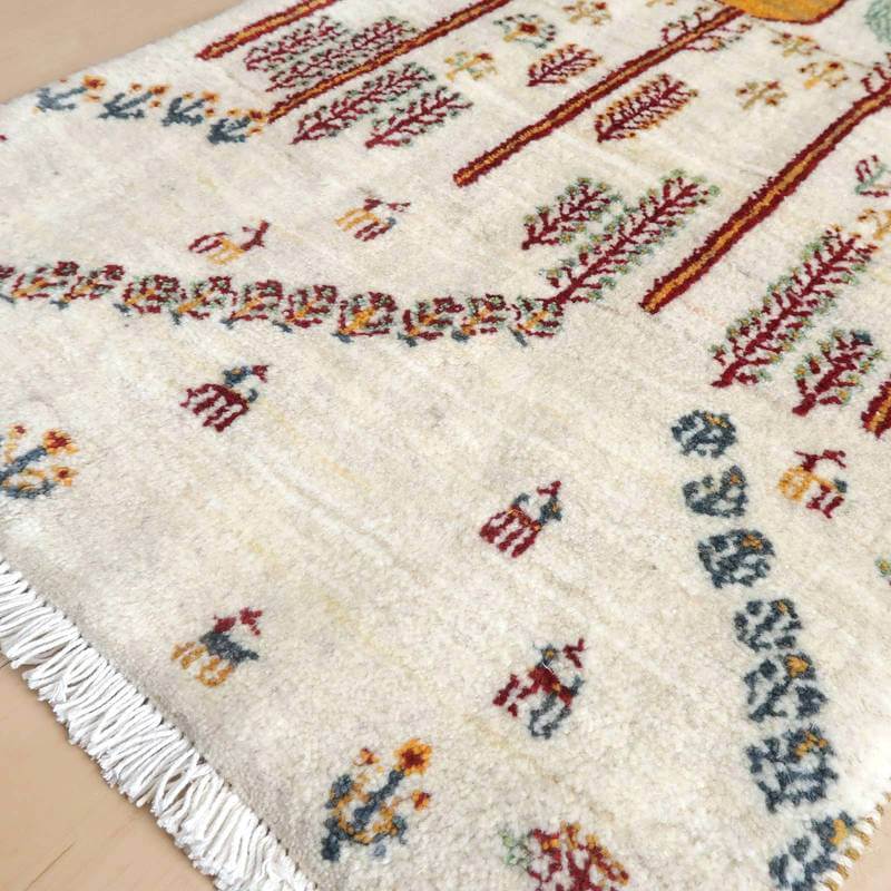 丁寧に手織りされたウールのギャッベラグが床に敷かれており、ペルシャ絨毯専門店の通販で購入可能な魅力的なデザインが際立っている。