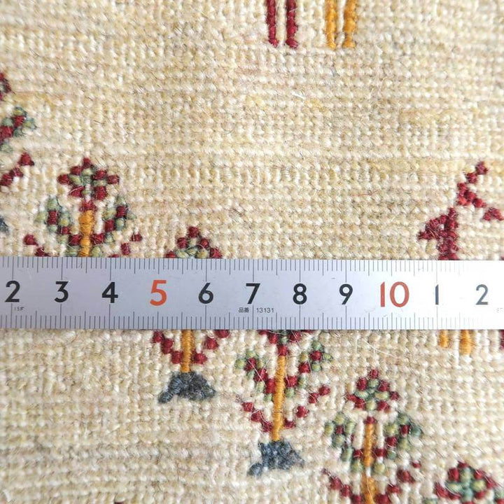 白を基調にしたギャッベのラグが手織りで丁寧に仕上げられ、ペルシャ絨毯専門店の通販でウールの温かみが感じられる織り目が際立っている。