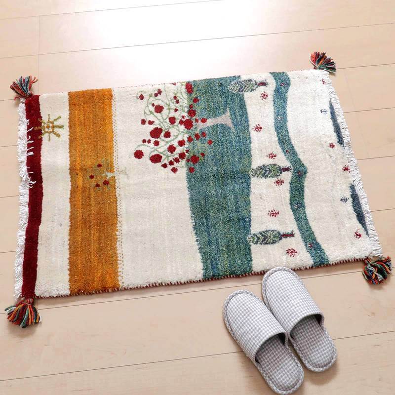 手織りウールのギャッベラグが、色鮮やかな模様とともに玄関に敷かれ、ペルシャ絨毯専門店の通販商品としてぬくもりを感じる。