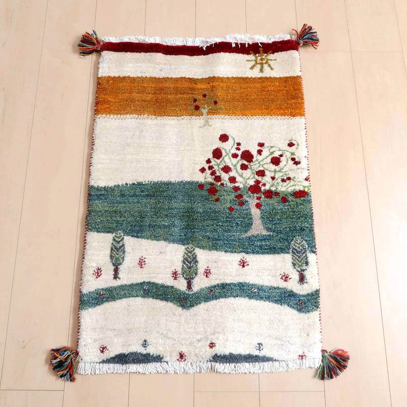 ギャッベ／ルリバフ 87×58cm（HSS-71865）は、明るい色合いで丁寧に手織りされたウールのギャッベラグが、ペルシャ絨毯専門店の床に敷かれている。