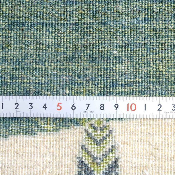 緻密に織られた手織りのウール製ギャッベラグの繊細な模様が定規とともに接写され、ペルシャ絨毯専門店の通販でそのディテールが際立っています。