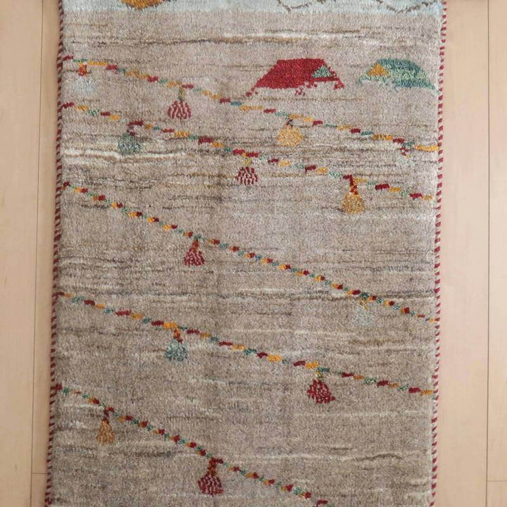 手織りのウールを使用したギャッベラグが、ペルシャ絨毯専門店の通販で提供され、床に温かみのある模様が広がっています。