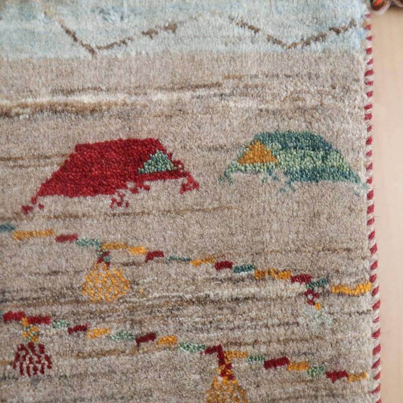 手織りのギャッベラグの一部には、赤や緑の幾何学模様が丁寧に描かれ、ウールの優しい質感が際立っている。