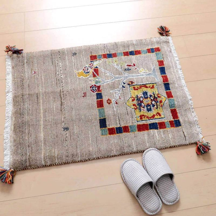 温かみのあるペルシャ絨毯風の手織りギャッベラグがウールの柔らかな質感で床に敷かれている。