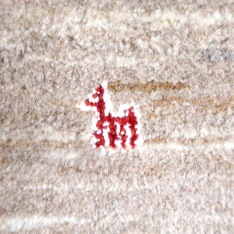 赤い模様が特徴的な手織りのギャッベラグが、ウール素材の暖かみを感じさせる織り目の中に際立っている。