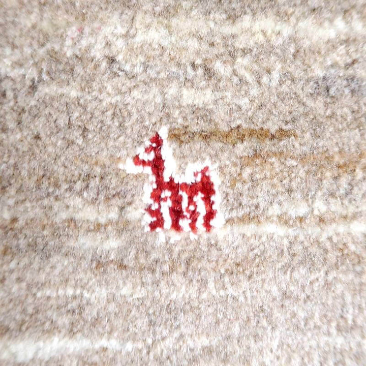 赤い模様が特徴的な手織りのギャッベラグが、ウール素材の暖かみを感じさせる織り目の中に際立っている。