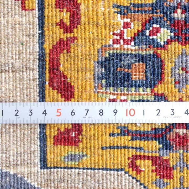 手織りのギャッベラグの緻密な織り目が、鮮やかなペルシャ絨毯の模様とともに定規で計測されている様子が細部まで見える。