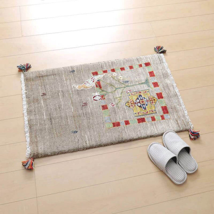 ウール素材で手織りされたペルシャ絨毯専門店のギャッベラグが、落ち着いた模様とぬくもりを感じさせる色合いで床に敷かれている。