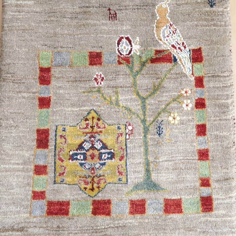 手織りのウール素材で丁寧に織られたギャッベラグは、ペルシャ絨毯専門店の通販で購入でき、温かみのある色彩とデザインが床に映えている。