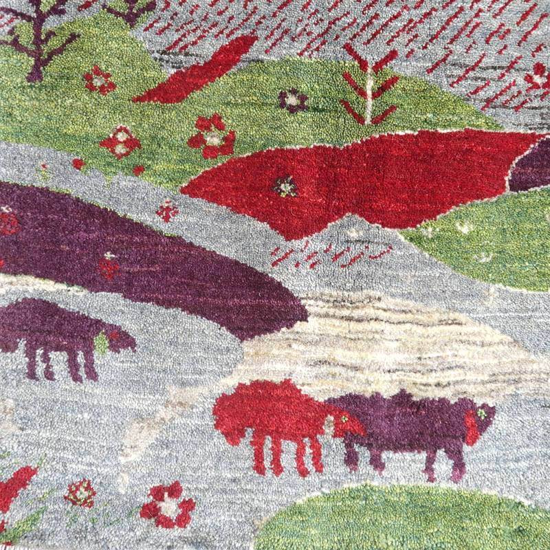 緑や赤の鮮やかな模様が広がる手織りウールのギャッベラグには、ペルシャ絨毯専門店ならではのぬくもりが感じられる。