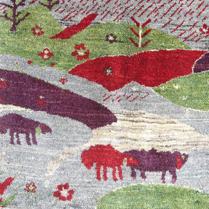 緑や赤の鮮やかな模様が広がる手織りウールのギャッベラグには、ペルシャ絨毯専門店ならではのぬくもりが感じられる。