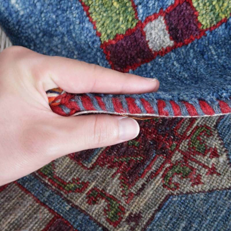 手織りのギャッベラグをめくると、濃密なウールの織り目と鮮やかな色彩が際立っている。