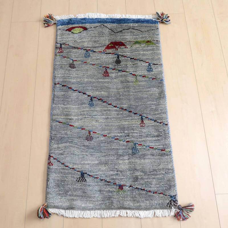 ギャッベ／ルリバフ 93×53cm（HSS-72514）は、手織りの温もりが感じられるウール素材のギャッベラグが、木目の床の上でペルシャ絨毯専門店の通販商品として優雅に広がっている。