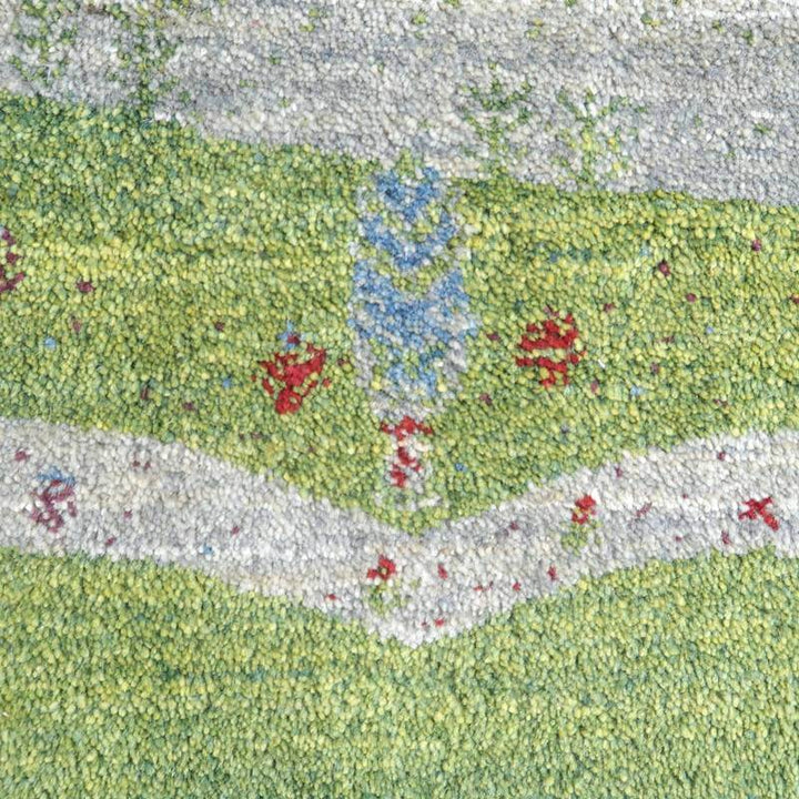 緑と青の模様が鮮やかに織り込まれた手織りウール製のギャッベラグが見え、ペルシャ絨毯の専門店で通販可能なデザインが際立っています。