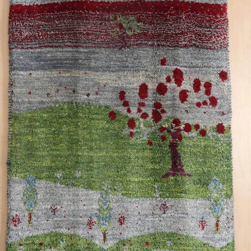 緑と赤の色彩が鮮やかに織り込まれた手織りのギャッベラグが、ペルシャ絨毯の専門店で通販されている。