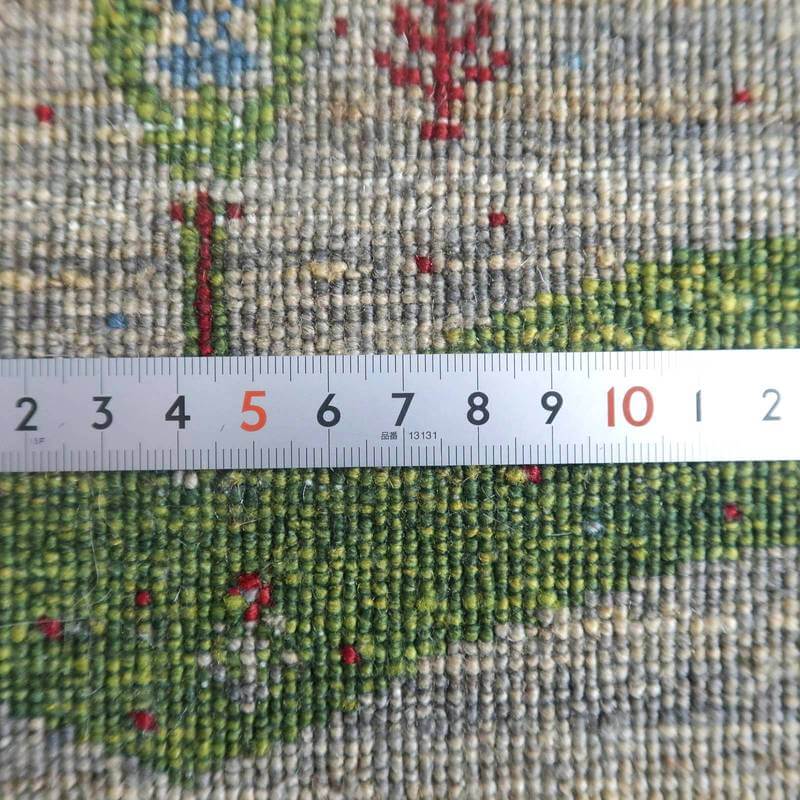 緻密に手織りされたウールのギャッベラグが、定規と並べられ織りの密度が際立っている。