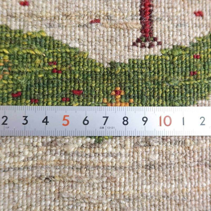 手織りのギャッベラグの緻密な織り目が定規と共に詳細に映し出され、ウール素材の質感とペルシャ絨毯専門店ならではの温かみが感じられる。