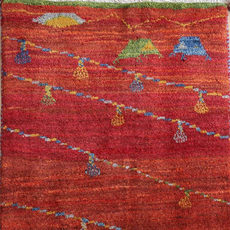 温かみのある赤い手織りのギャッベラグが、ペルシャ絨毯専門店の通販で提供され、緻密なウールの織り目が際立っている。