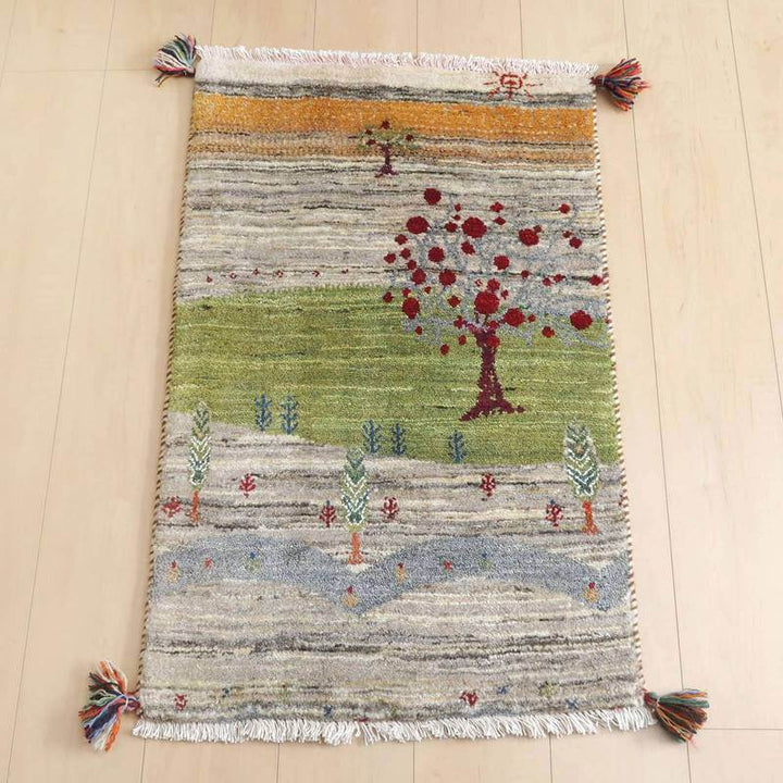 ギャッベ／ルリバフ 91×57cm（HSS-73129）は、手織りのウールで丁寧に作られたギャッベのラグが、ペルシャ絨毯専門店の通販で提供され、豊かな自然のモチーフが床に広がっています。