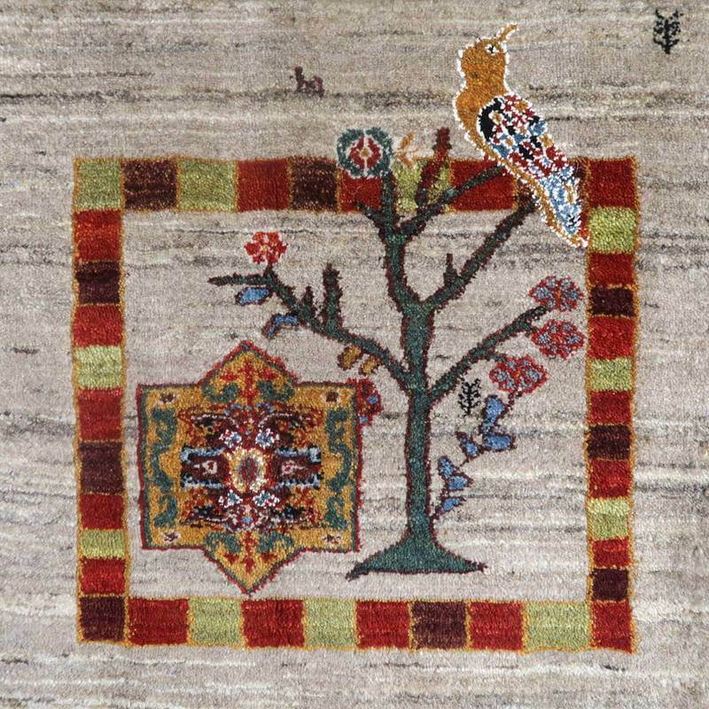 手織りのウール製ギャッベラグに描かれた鳥と木のモチーフが、ペルシャ絨毯の専門店で通販される逸品として際立っている。