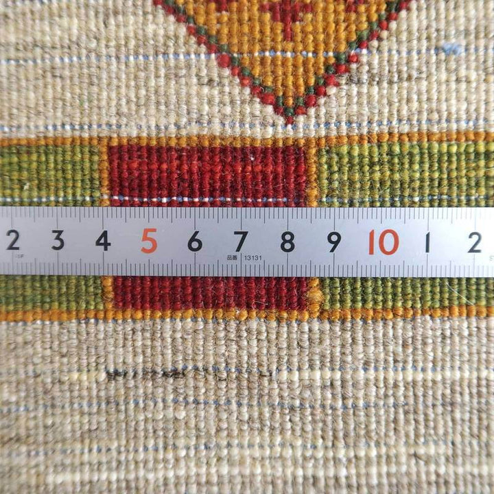 手織りのウール製ギャッベラグの繊細な織り目が、定規との比較でその細やかさが際立っている。