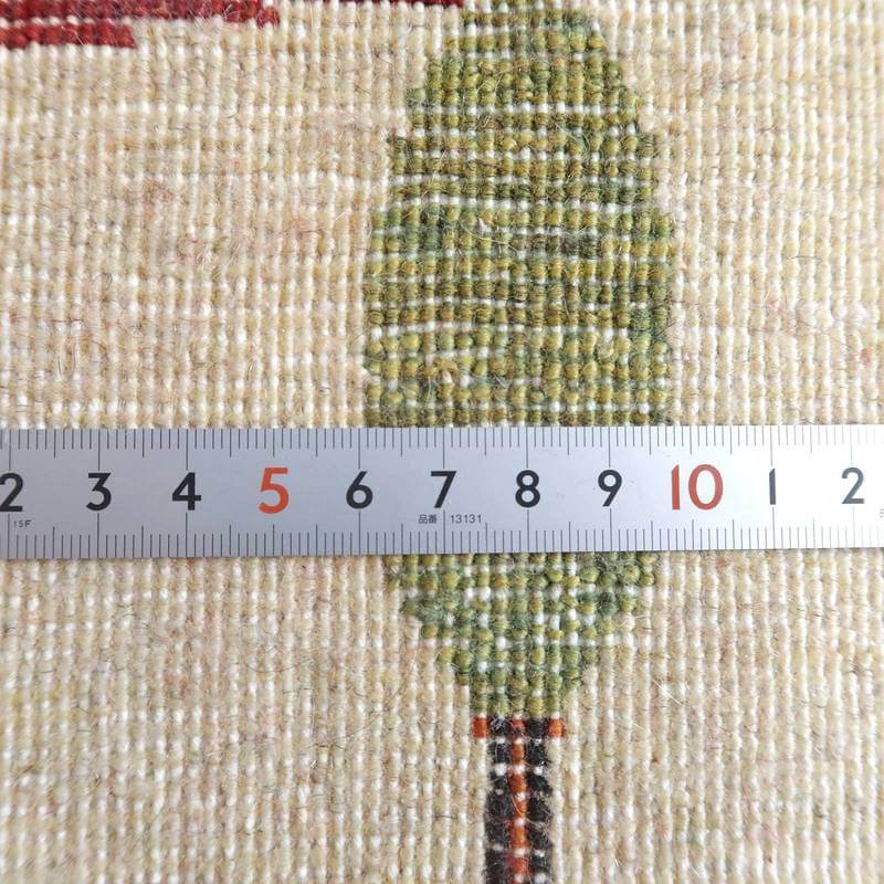 手織りのギャッベラグの織り目が、定規によって細やかに計測され、そのウールの質感とペルシャ絨毯ならではの模様が際立っています。