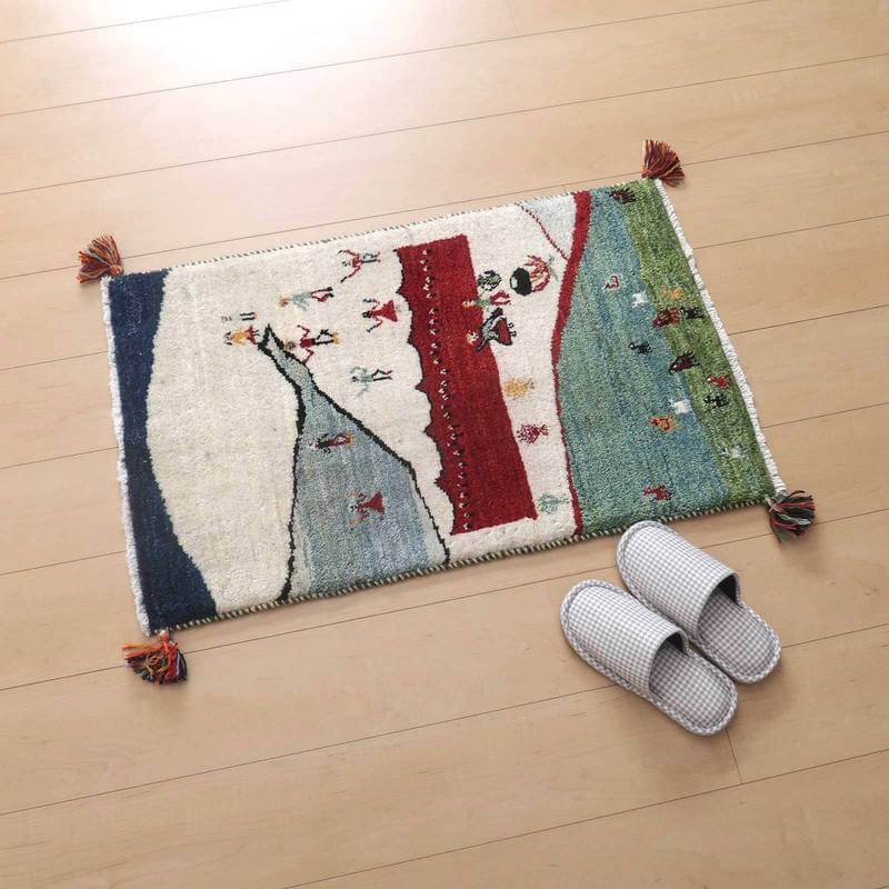 色鮮やかな手織りのギャッベラグが木製の床に敷かれ、ウール素材の温かみが感じられるペルシャ絨毯の専門店通販商品です。