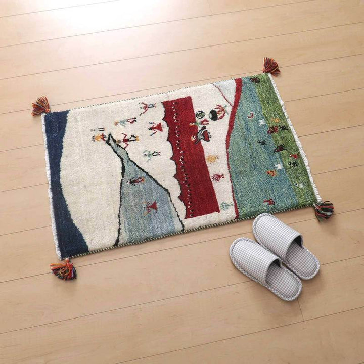 色鮮やかな手織りのギャッベラグが木製の床に敷かれ、ウール素材の温かみが感じられるペルシャ絨毯の専門店通販商品です。